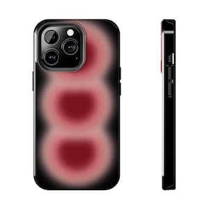 May include: A black phone case with a red and pink abstract design. The case has a raised camera bump and a black border.