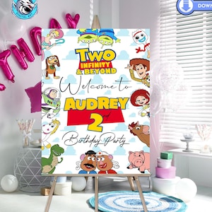 May include: A white welcome sign with a red border featuring characters from the Toy Story movie franchise. The sign says "Two Infinity & Beyond Welcome to Audrey 2 Birthday Party".