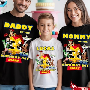 May include: Three matching black and white t-shirts with a Toy Story theme. The shirts read "Daddy of the Birthday Boy Story", "Lucas", and "Mommy of the Birthday Boy Story". Each shirt features a colorful graphic of Toy Story characters.