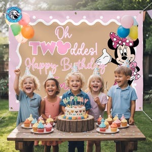 May include: A rectangular birthday party backdrop featuring a light pink border with white polka dots, a tan center, and the text Oh TWOoddes! Happy Birthday. A cartoon mouse character is on the right, and colorful balloons are in the corners.