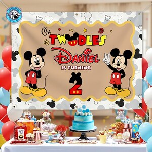 May include: A rectangular party backdrop featuring Mickey Mouse, the text "Oh Twodles", "Daniel is turning", and the number "2". The design includes a tan center with a scalloped gold border, surrounded by a white background with gray Mickey silhouettes.