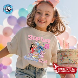 Puede incluir: Una ni&ntilde;a peque&ntilde;a lleva una camiseta beige con un gr&aacute;fico colorido con los personajes Stitch y Angel, el texto "Sophia 8 Birthday Girl" y una tarta de cumplea&ntilde;os. La ni&ntilde;a sonr&iacute;e, con un lazo rosa en el pelo.