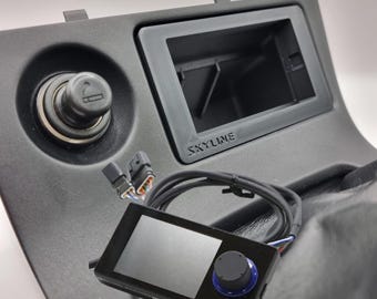 May include: A black car dashboard with a cigarette lighter, a black screen with the word "SKYLINE" on it, and a black device with a blue knob and a screen.