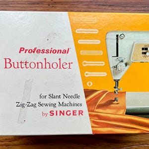 May include: A white box with a yellow background and a picture of a sewing machine. The box says "Professional Buttonholer for Slant Needle Zig-Zag Sewing Machines by SINGER".