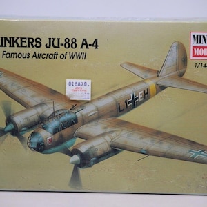 May include: A model kit box featuring a Junkers JU-88 A-4 aircraft. The box art depicts a detailed illustration of the WWII German bomber in flight, with brown and green camouflage. The box includes the text "JUNKERS JU-88 A-4" and "Famous Aircraft of WWII".