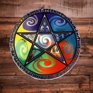 May include: A colorful pentagram design with a circular border. The design features elements of air, water, earth, and fire, with text that includes words like creativity, love, and wisdom. The background is a wooden surface.