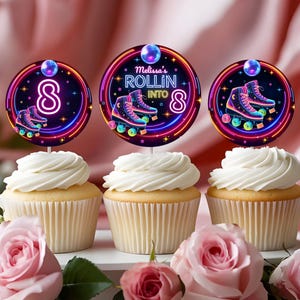 May include: Three cupcakes with white frosting are decorated with toppers featuring roller skates and the text "Melissa's Rolling Into 8". The toppers have a neon design with pink, blue, and yellow colors. Pink roses are in the foreground.