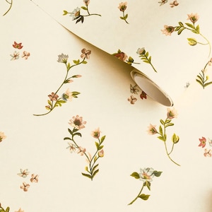 Könnte beinhalten: Cremefarbene Tapete mit einem sich wiederholenden Muster aus zarten Blumenzweigen. Die Blumen sind in Rosa, Rot und Weiß gehalten, mit grünen Blättern. Eine Rolle der Tapete ist teilweise abgerollt.