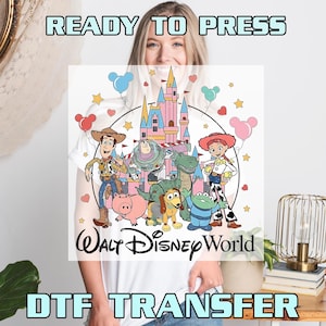May include: White DTF transfer featuring a colorful illustration of Disney characters, including Woody, Buzz Lightyear, and Jessie, in front of a pink castle. The words "Walt Disney World" are below the characters, with "READY TO PRESS" and "DTF TRANSFER" above and below.