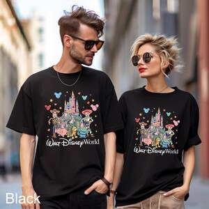 May include: Black t-shirts featuring a colorful graphic of Disney characters and a castle, with the text "Walt Disney World". The shirts are worn by two people. The word "Black" is printed at the bottom left.