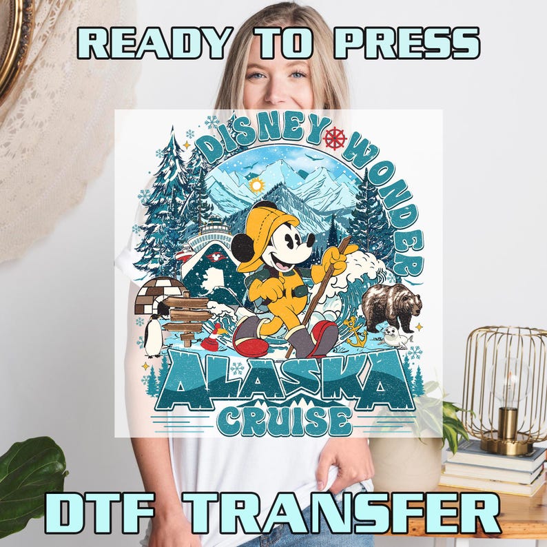 May include: A white t-shirt featuring a colorful graphic of Mickey Mouse in Alaska. The design includes text that reads "Disney Wonder Alaska Cruise". The image also includes text that reads "READY TO PRESS" and "DTF TRANSFER".