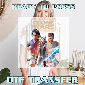 May include: White t-shirt featuring a DTF transfer of Star Wars: The Clone Wars characters. The design includes Anakin Skywalker, Ahsoka Tano, Obi-Wan Kenobi, and Darth Maul. Text at the top reads "READY TO PRESS" and at the bottom "DTF TRANSFER".