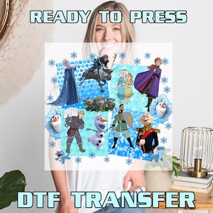 May include: A DTF transfer featuring characters from the movie Frozen. The design includes Elsa, Anna, Olaf, Kristoff, Sven, and other characters on a blue and white background. The text "READY TO PRESS" and "DTF TRANSFER" are displayed.