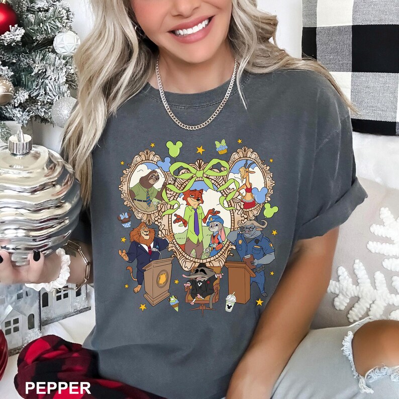 May include: Dark grey t-shirt featuring a colorful cartoon illustration of characters from a popular animated movie. The design includes framed portraits of various animal characters, with a large green bow and decorative elements.