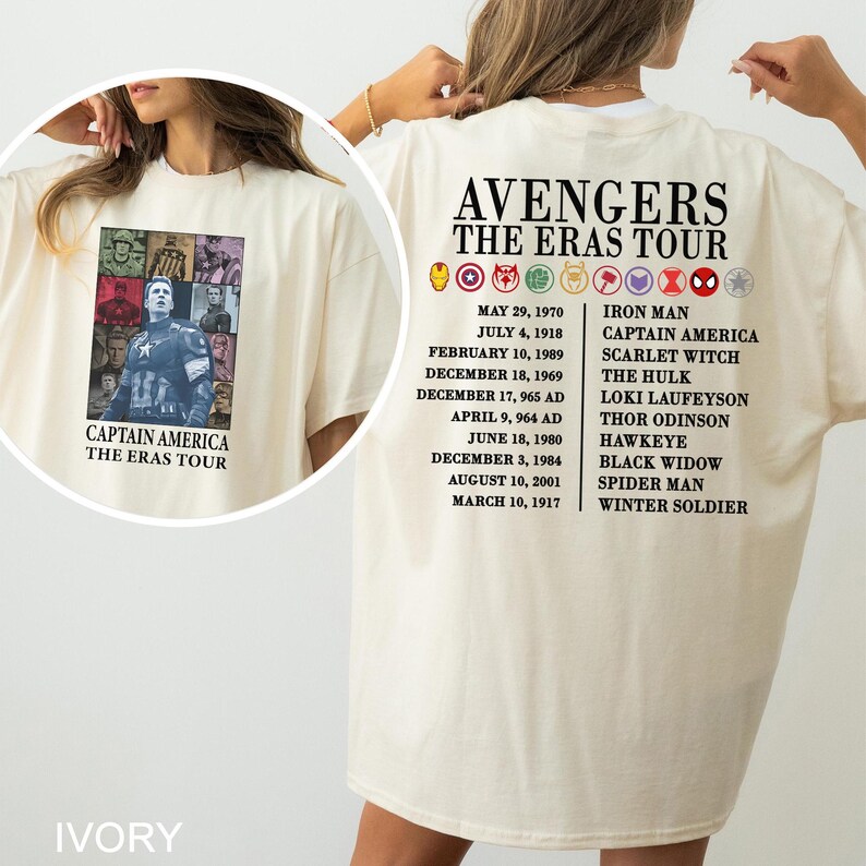 May include: Ivory-colored t-shirt featuring a Captain America graphic on the front and a list of Avengers characters and dates on the back. The shirt has the text "AVENGERS THE ERAS TOUR".