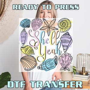 May include: DTF transfer featuring a collection of seashells in various shapes and colors, with the phrase "Shell Yeah" in a playful font. The design includes a starfish and several types of shells, perfect for creating beach-themed apparel or crafts.