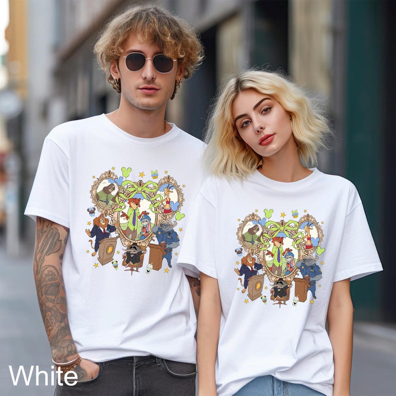 May include: White t-shirts featuring a colorful cartoon design with various animal characters in a frame. The shirts are short-sleeved and worn by two people. The word "White" is printed at the bottom left.
