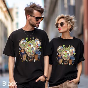 May include: Black t-shirts featuring a colorful cartoon design with various characters in ornate frames. The design includes a central figure in a green coat, surrounded by other animated figures. The word "Black" is printed at the bottom.