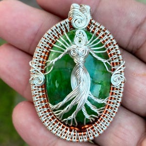 May include: A silver and copper wire wrapped pendant featuring a green agate stone with a silver wire tree of life design.