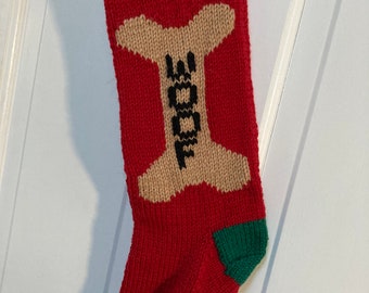 Könnte beinhalten: Rote, grüne und weiße gestrickte Weihnachtsstrumpf mit dem Namen "BAILEY" und einem braunen Knochen mit dem Wort "WOOF" darauf.