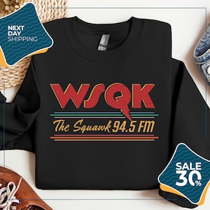 May include: Black sweatshirt with the text "WSQK The Squawk 94.5 FM" in red, yellow, green, and blue. The sweatshirt has a crew neck and long sleeves. The design is vintage-inspired.