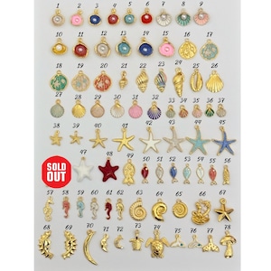 May include: A set of 78 gold-tone metal charms with various sea-themed designs, including seashells, starfish, fish, seahorses, and a turtle. The charms are arranged in rows on a white background, numbered 1 through 78.