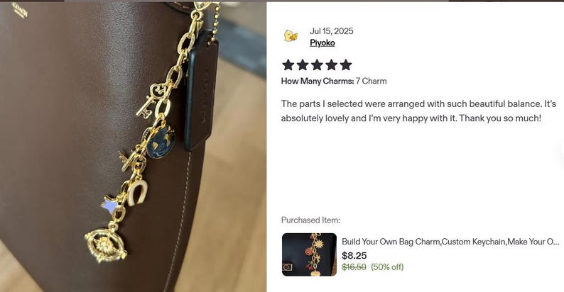 K&ouml;nnte beinhalten: Eine goldfarbene Charm-Kette mit verschiedenen Anh&auml;ngern, darunter ein Schl&uuml;ssel, ein Globus, ein Hufeisen und ein Auge, die an einer braunen Ledertasche befestigt sind. Die Charms sind detailliert und dekorativ.
