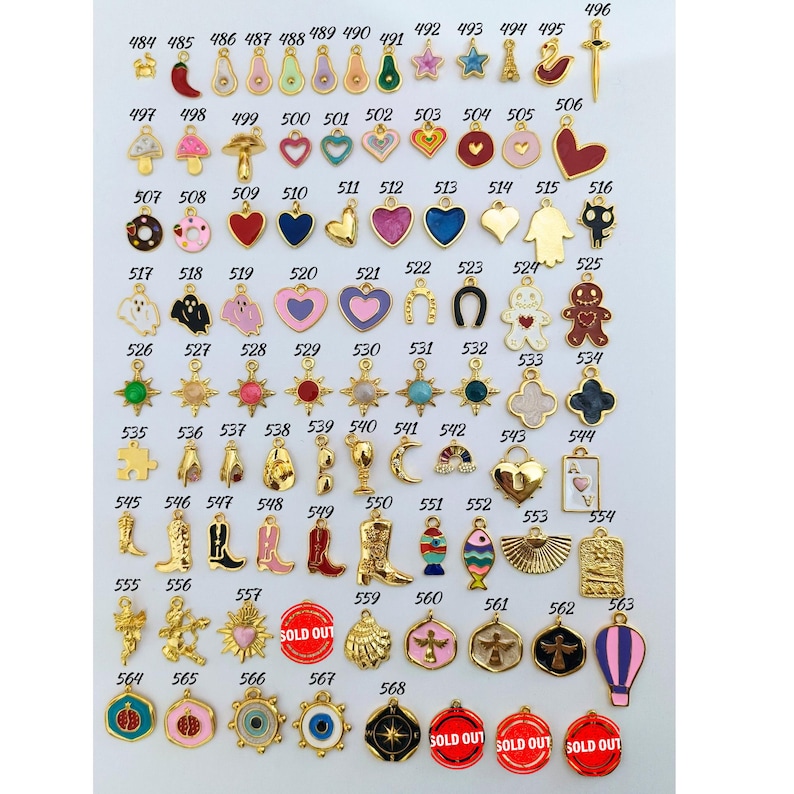 May include: Assortment of 68 gold-tone charms with colorful enamel designs. The charms feature various shapes, including hearts, stars, animals, and abstract designs. Some charms have text, such as "SOLD OUT".