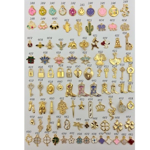 May include: Assortment of 50 gold-tone metal charms with various enamel colors and designs. Charms include a donut, cactus, bee, lock, cowboy boot, star, crown, snake, dragonfly, and clover.
