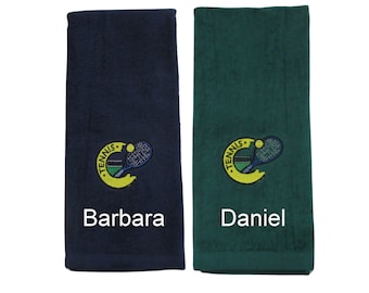Könnte beinhalten: Zwei personalisierte Tennistücher, eines dunkelblau und eines grün, mit einem gestickten Tennisracket- und Balldesign und den Namen "Barbara" und "Daniel" darunter.