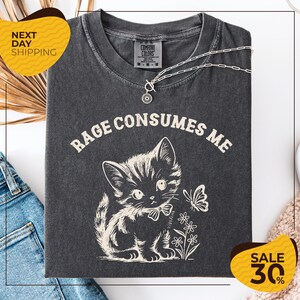 a gray t-shirt with a cat and flowers printed on it, along with a yellow and black sale sign indicating a 30% discount.