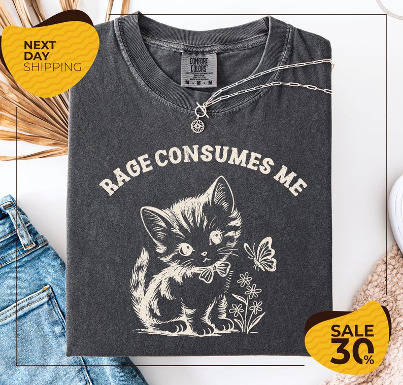 a gray t-shirt with a cat and flowers printed on it, along with a yellow and black sale sign indicating a 30% discount.