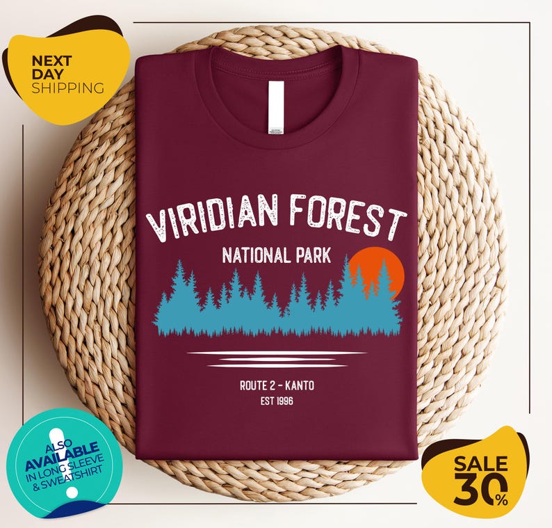 a burgundy t-shirt with a graphic design of a forest scene, along with text indicating it is a t-shirt for the Viridian Forest National Park.