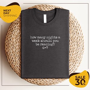 a gray t-shirt with a humorous text printed on it, placed on a woven placemat.