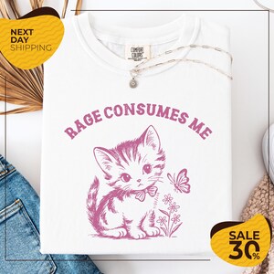 a white t-shirt with a pink cat and a butterfly graphic, along with a yellow and black sale tag indicating a 30% discount.