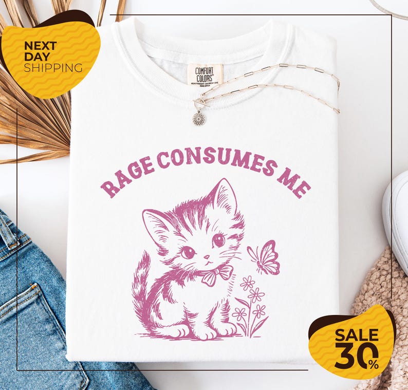 a white t-shirt with a pink cat and a butterfly graphic, along with a yellow and black sale tag indicating a 30% discount.