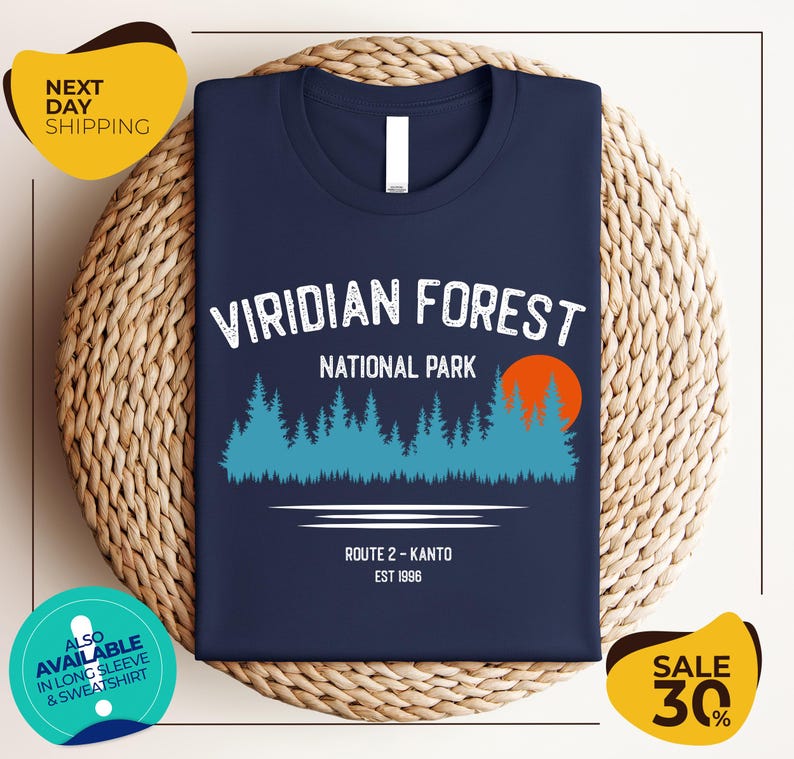 a navy blue t-shirt with a graphic design of a forest and a sunset, along with text indicating it is a t-shirt for the Viridian Forest National Park.