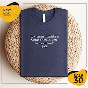 a blue t-shirt with a humorous text printed on it, placed on a woven placemat.