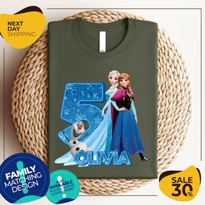 a green shirt with a picture of two frozen princesses on it