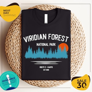 a black t-shirt with a graphic design depicting a forest scene, along with text indicating the location as Viridian Forest National Park.