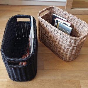 May include: Two woven magazine holders, one black and one brown, with a stack of books in the brown holder.