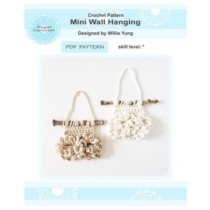 Könnte beinhalten: Zwei gehäkelte Wandbehänge mit einem rustikalen Zweig, der oben befestigt ist. Einer ist beige und der andere ist weiß. Die Behänge sind mit einem strukturierten Stich gearbeitet, der kleinen, bauschigen Wolken ähnelt.