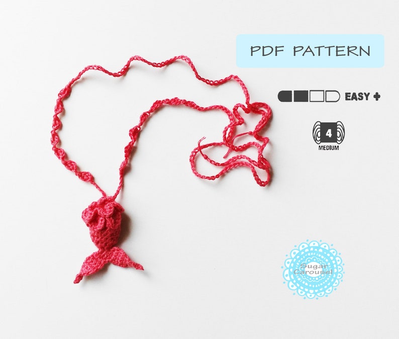 May include: A pink crocheted mermaid tail necklace with a PDF pattern for crocheting. The pattern is rated easy and uses medium weight yarn.