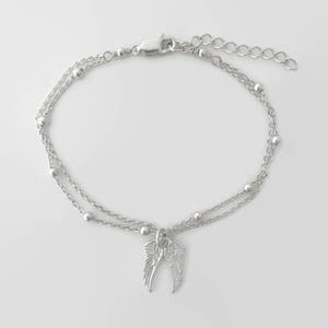 May include: Silver double chain anklet with a small angel wing charm.