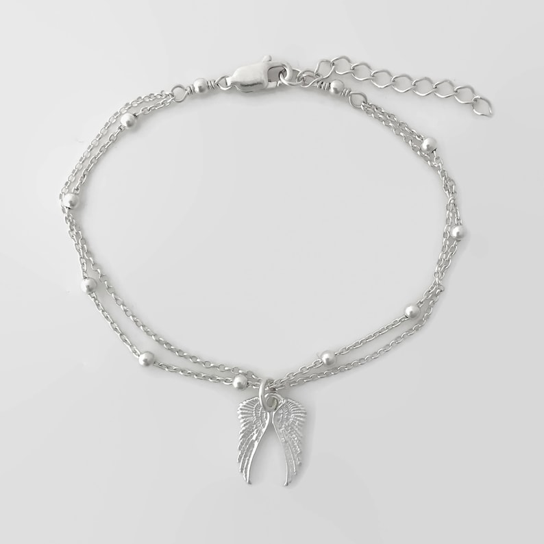 May include: Silver double chain anklet with a small angel wing charm.