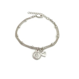 May include: A silver bracelet with two chains, a small heart charm, and a round charm with a detailed design.