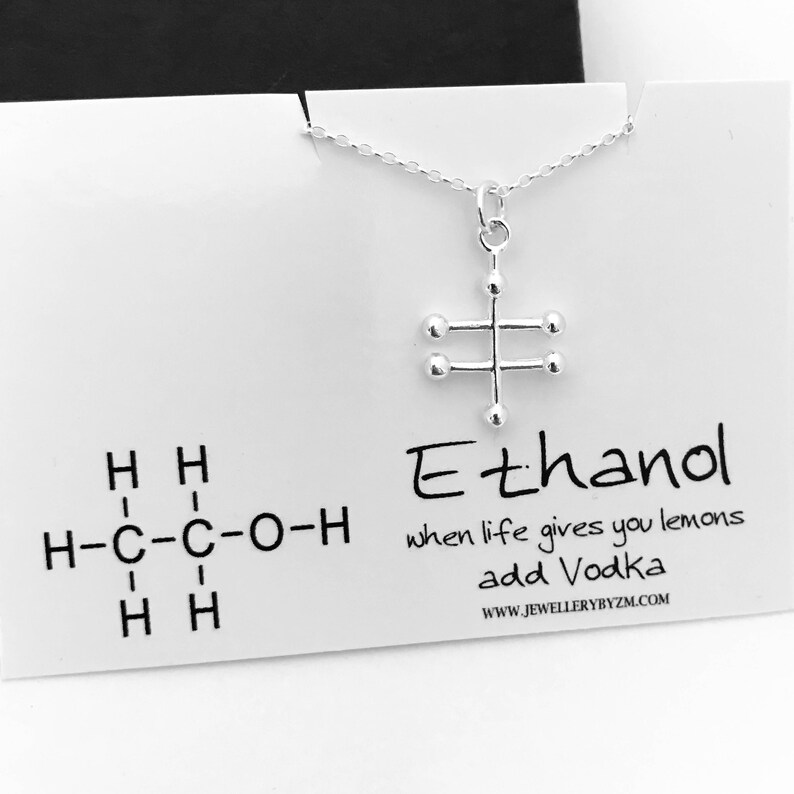 May include: Silver necklace with a pendant shaped like the chemical structure of ethanol. The pendant is on a white card with the text "Ethanol" and the chemical formula for ethanol. The card also says "when life gives you lemons add Vodka" and "www.jewellerybyzm.com".