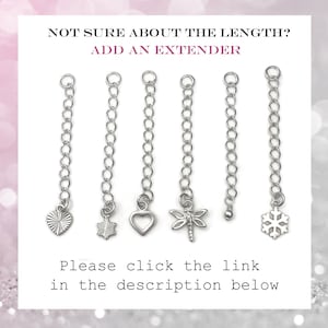 May include: Five silver chain extenders with different charms. The charms include a heart, a star, a dragonfly, a bead, and a snowflake.