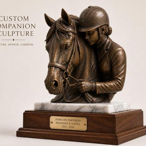 May include: A bronze sculpture of a horse and rider, mounted on a marble and wood base. The rider, wearing a helmet, embraces the horse's head. The base includes a plaque that reads "FOREVER PARTNERS MIDNIGHT & SOPHIA 2012-2024". The sculpture is a custom companion piece.