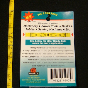 May include: A blue and white package of Peel & Stick Rulers. The package lists different types of rulers, including Handy-Rule, Handy-Center, Combi-Rule, Combi-Center, Metri-Rule, Metri-Center, and Rod-Rule. The package also includes the company name, SE Rose Co., and website address, www.handyrule.com.